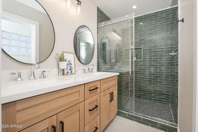 a bathroom with a double vanity sink mirror and shower