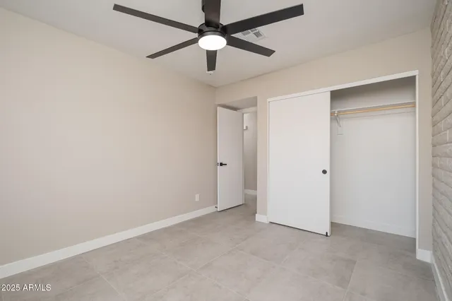 an empty room with a fan and a ceiling fan
