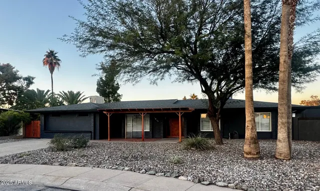 a front view of a house with a yard and trees