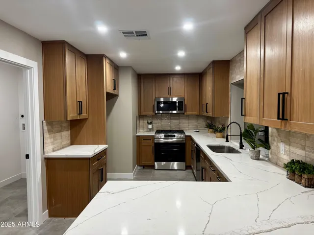 a kitchen with stainless steel appliances granite countertop a sink stove and refrigerator