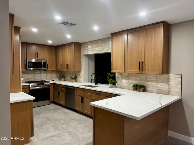 a kitchen that has a sink a stove top oven a refrigerator and a oven