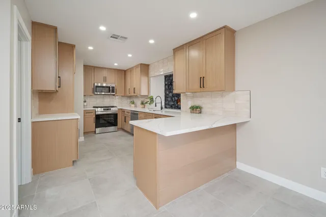 a kitchen with kitchen island sink stainless steel appliances and cabinets