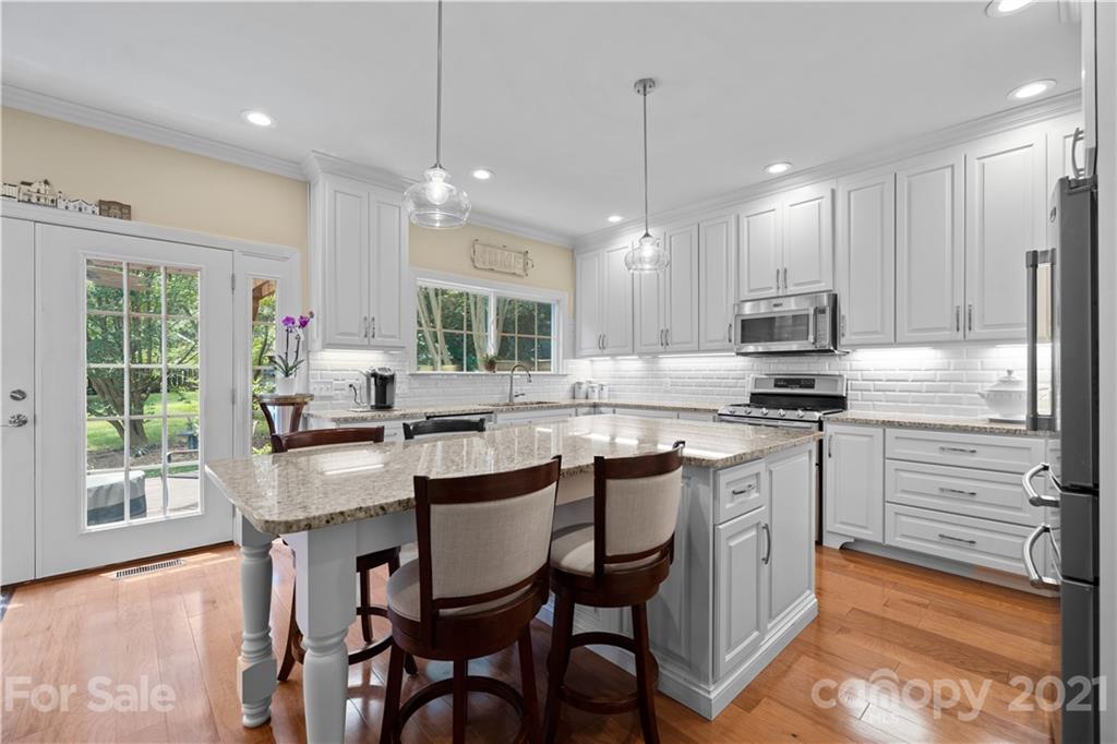 348 Gringley Hill Road Fort Mill, SC 29708 - Photo 3 of 33 a kitchen with kitchen island granite countertop a table chairs sink and cabinets