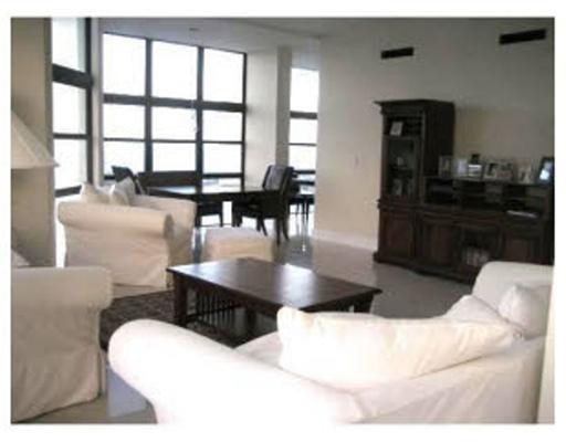 1925 Brickell Avenue, Unit DPH5 Miami, FL 33129 - Photo 1 of 4 a living room with couches a coffee table and kitchen view with wooden floor