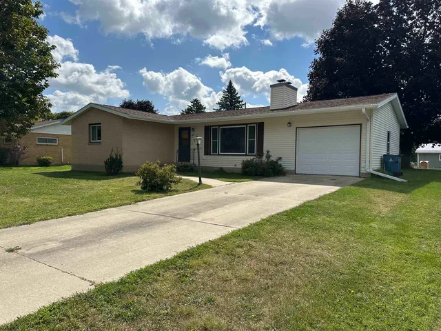 a view of a yard in front of a house with a large tree