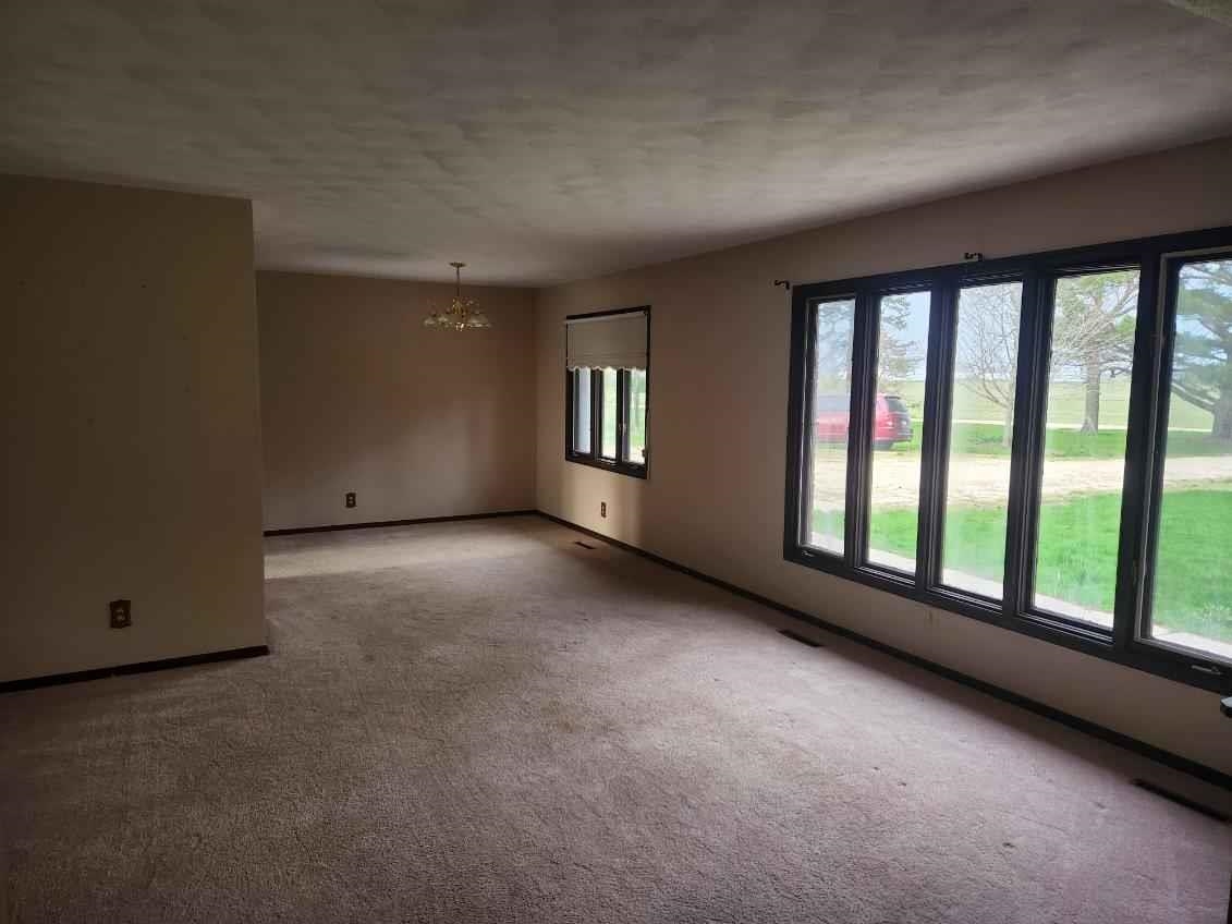 1281 Spring Center Road Belvidere, IL 61008 - Photo 6 of 19 a view of a big room with windows and chandelier
