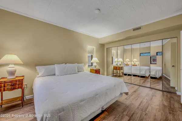 a spacious bedroom with a bed and a lamp