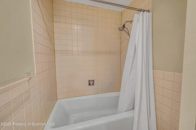 a bathroom with a shower and a bath tub
