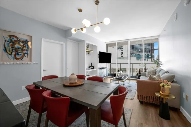 a living room with furniture kitchen view and a chandelier