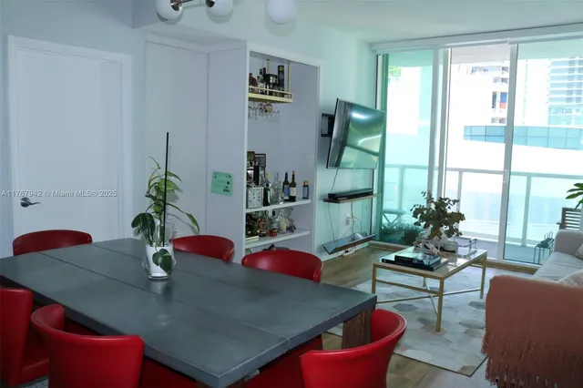 a living room with furniture kitchen view and large windows
