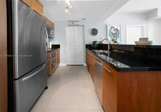 a kitchen with stainless steel appliances granite countertop a refrigerator and a sink