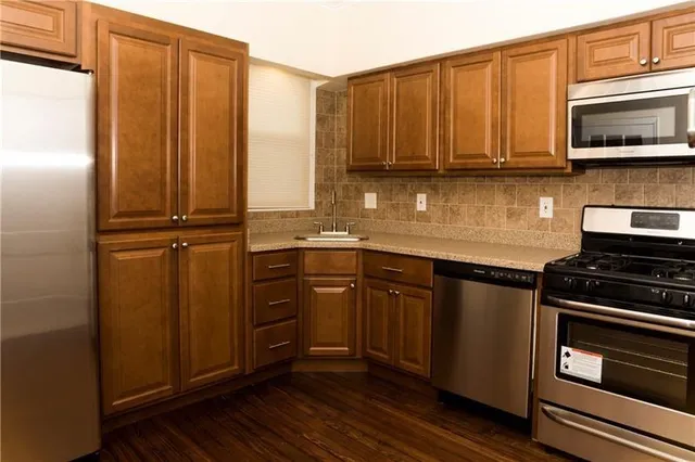 a kitchen with stainless steel appliances granite countertop a refrigerator stove and microwave
