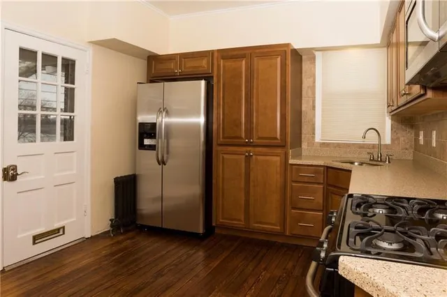 a kitchen with stainless steel appliances granite countertop a refrigerator stove and sink