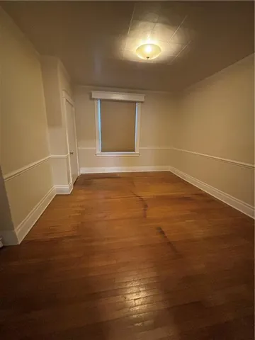 a view of an empty room with closet and a window