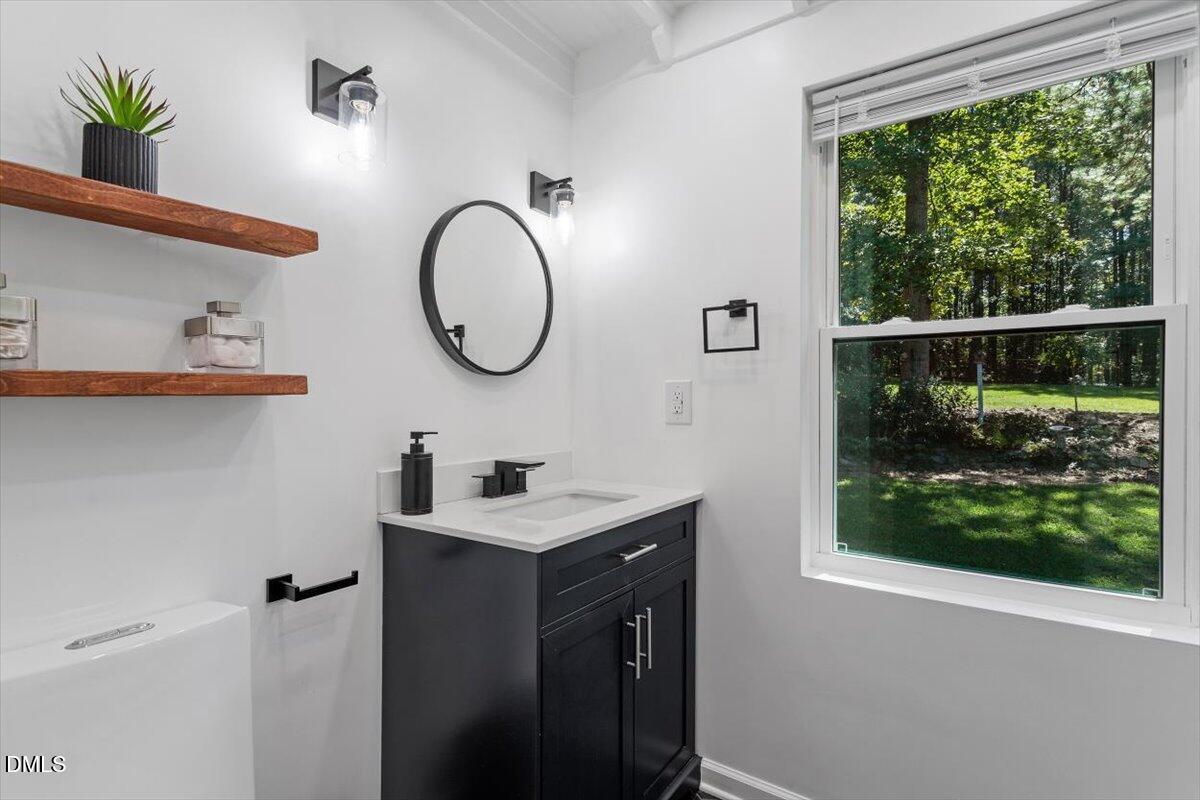 2129 Kelly Road Apex, NC 27502 - Photo 25 of 64 a bathroom with a sink a mirror and a window