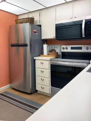 a kitchen with stainless steel appliances a refrigerator and cabinets