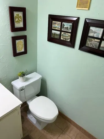 a white toilet sitting next to a white wall