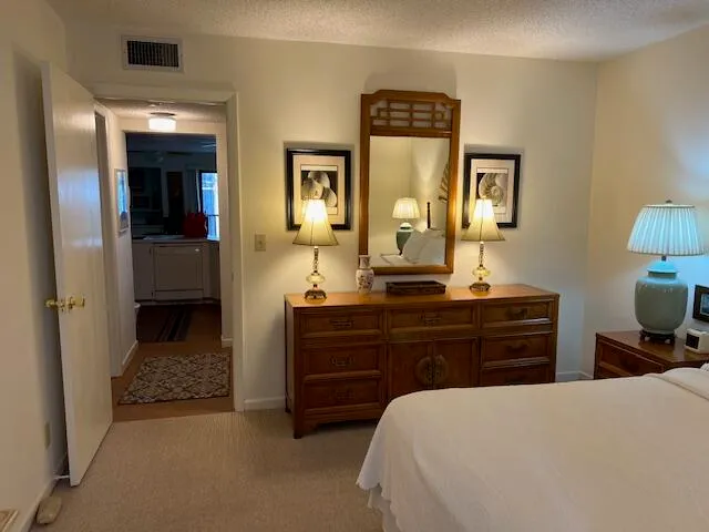 a bedroom with a bed and a mirror on dresser