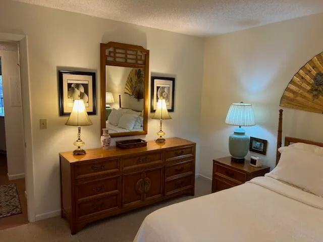 a bedroom with a bed and a mirror on dresser
