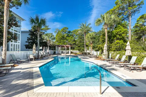 a patio with table and chairs and potted plants