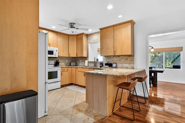 a kitchen with granite countertop a sink a stove and cabinets