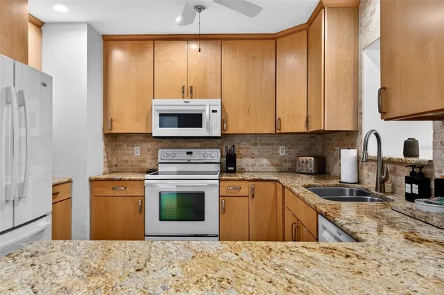a kitchen with stainless steel appliances granite countertop a stove refrigerator sink and dishwasher with wooden floor