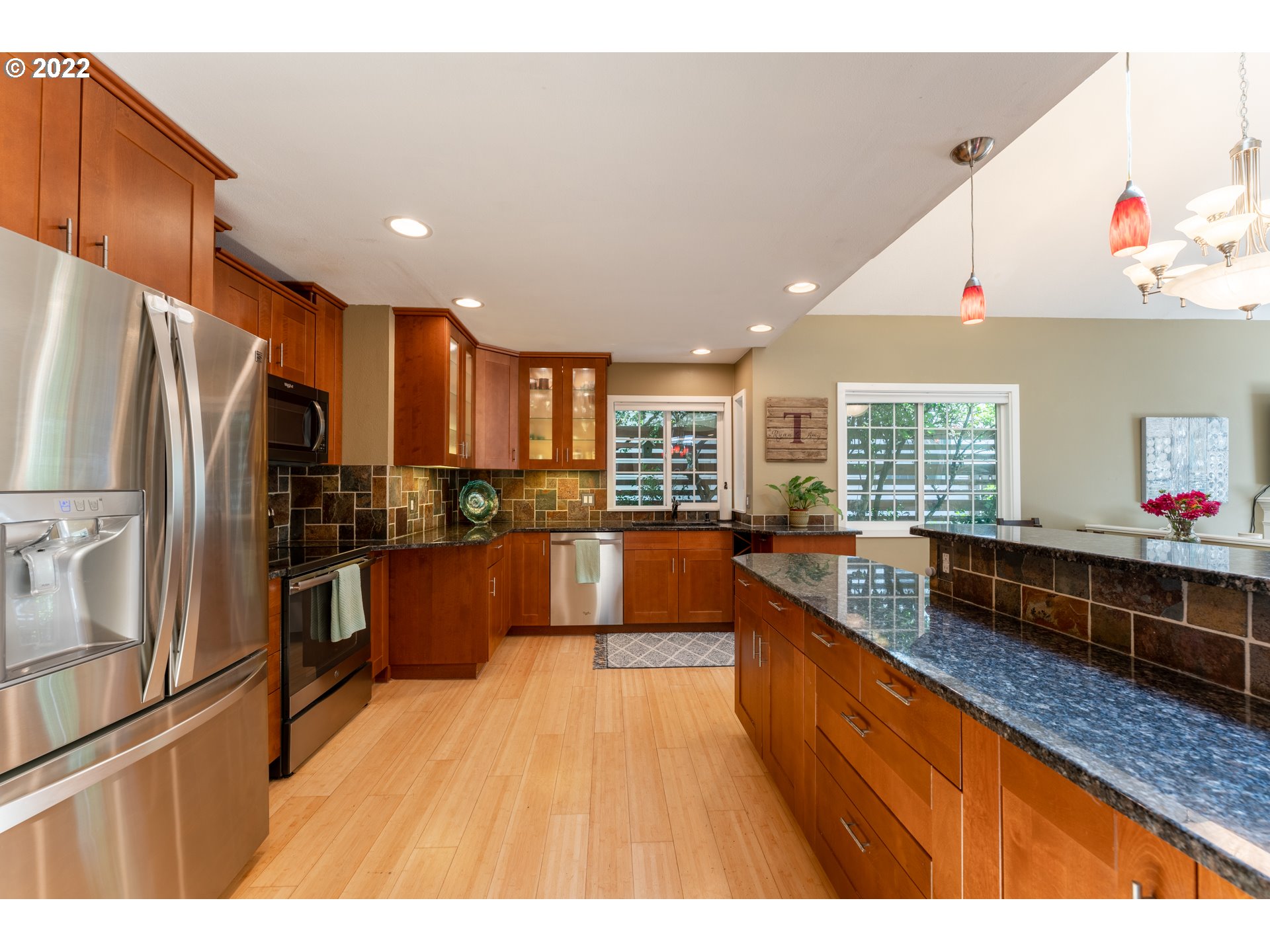 10594 Southwest Windsor Court Tigard, OR 97223 - Photo 5 of 31 a large kitchen with stainless steel appliances kitchen island granite countertop a refrigerator and a wooden cabinets