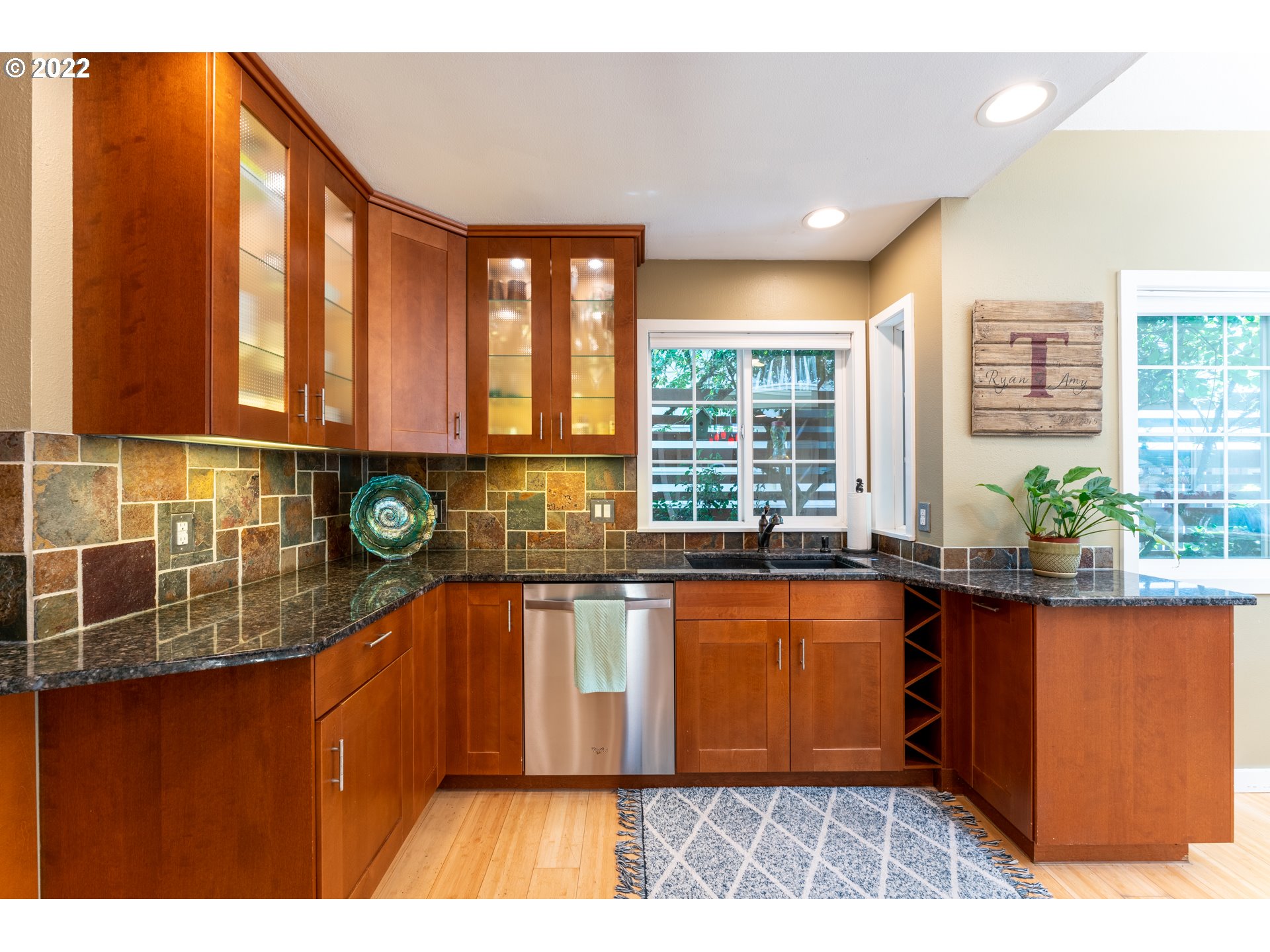 10594 Southwest Windsor Court Tigard, OR 97223 - Photo 6 of 31 a kitchen with granite countertop a stove a sink and a wooden cabinets