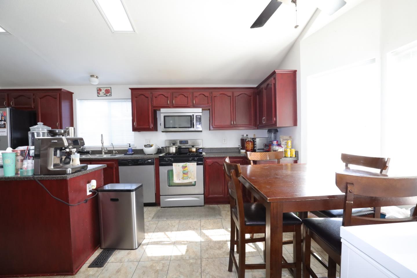 5450 Monterey Road, Unit 132 San Jose, CA 95111 - Photo 13 of 15 a kitchen with stainless steel appliances granite countertop a stove top oven a sink a dining table and chairs