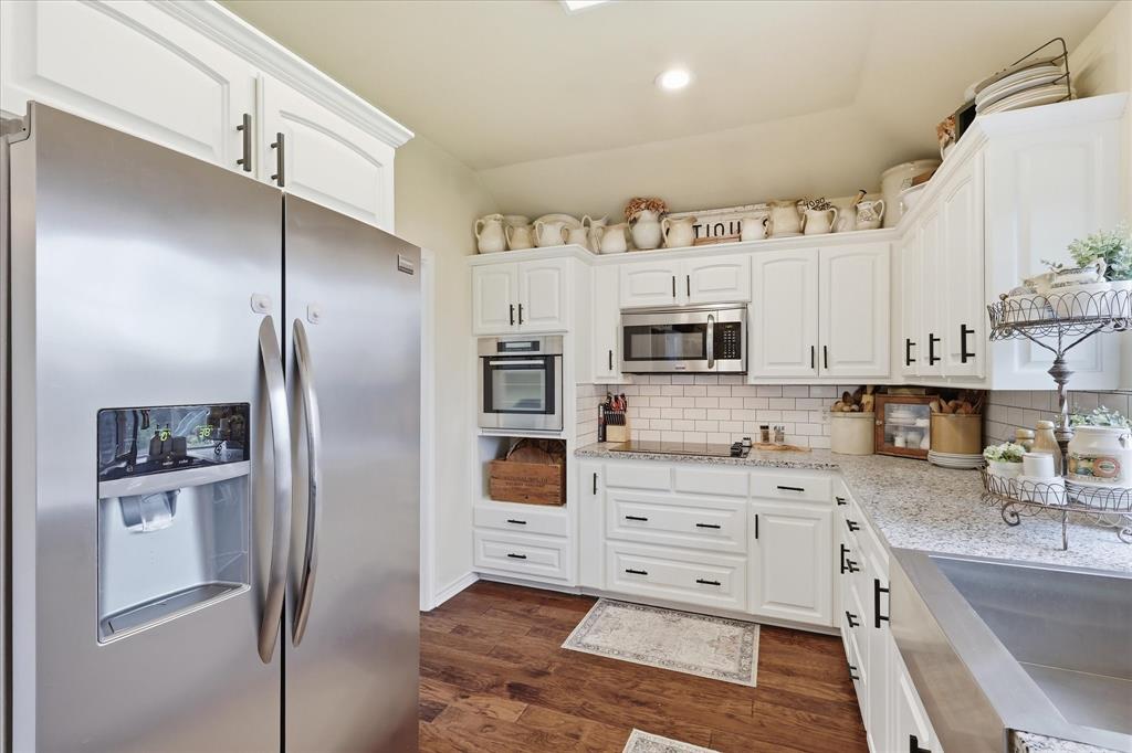 202 Colonial Heights Sanger, TX 76266 - Photo 13 of 27 a kitchen with stainless steel appliances kitchen island granite countertop a refrigerator and a sink