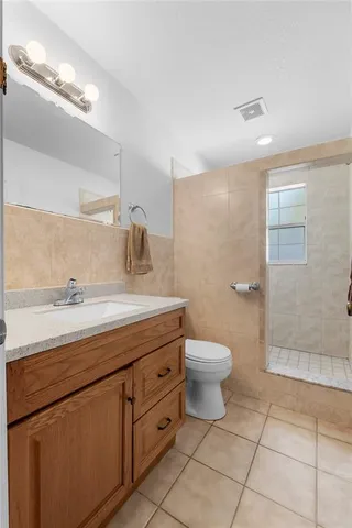 a spacious bathroom with a granite countertop sink a toilet and a shower