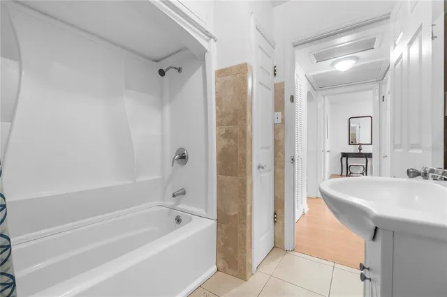 a bathroom with a bathtub a sink a mirror and a shower