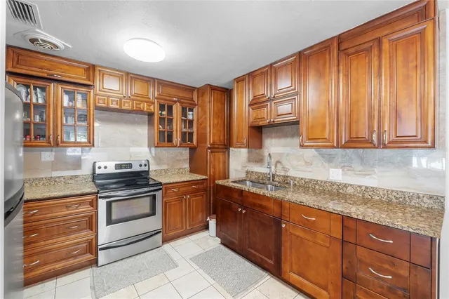 a kitchen with stainless steel appliances granite countertop wooden cabinets a sink and a stove
