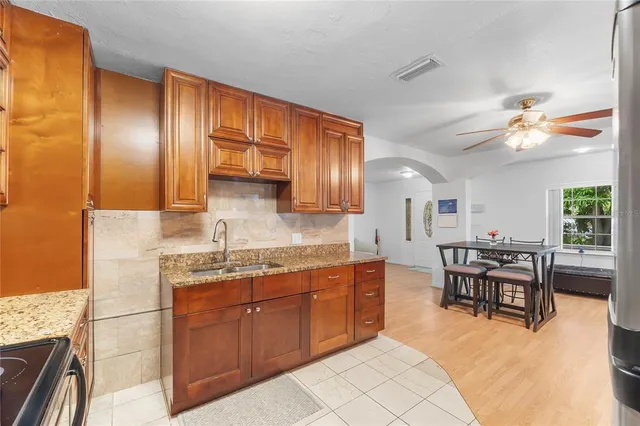 a kitchen with a sink dining table and chairs