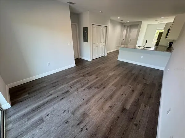 a view of an empty room with wooden floor
