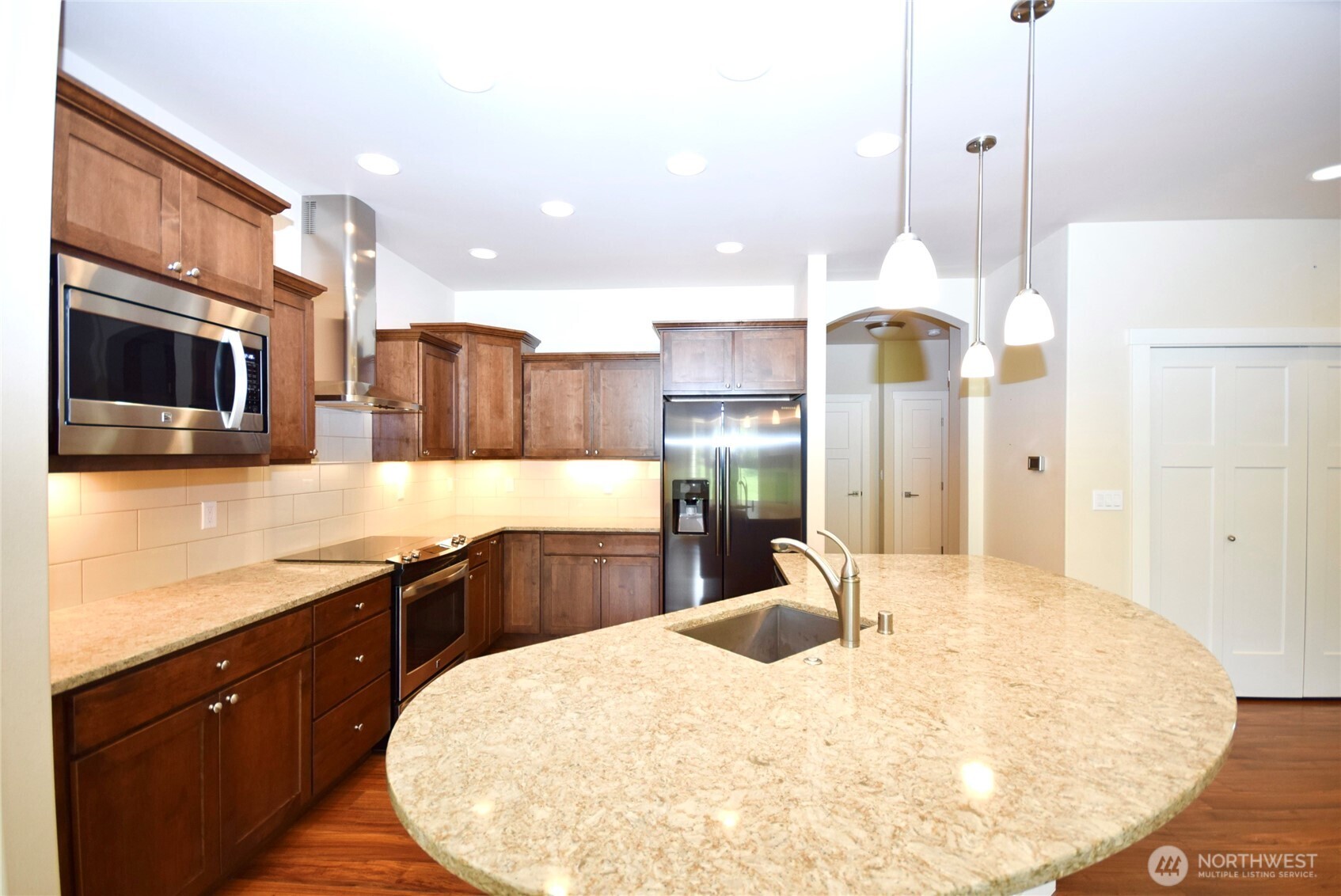 261 Mt Baker Drive, Unit B Sequim, WA 98382 - Photo 13 of 28 a kitchen with stainless steel appliances kitchen island granite countertop a sink a stove and a refrigerator
