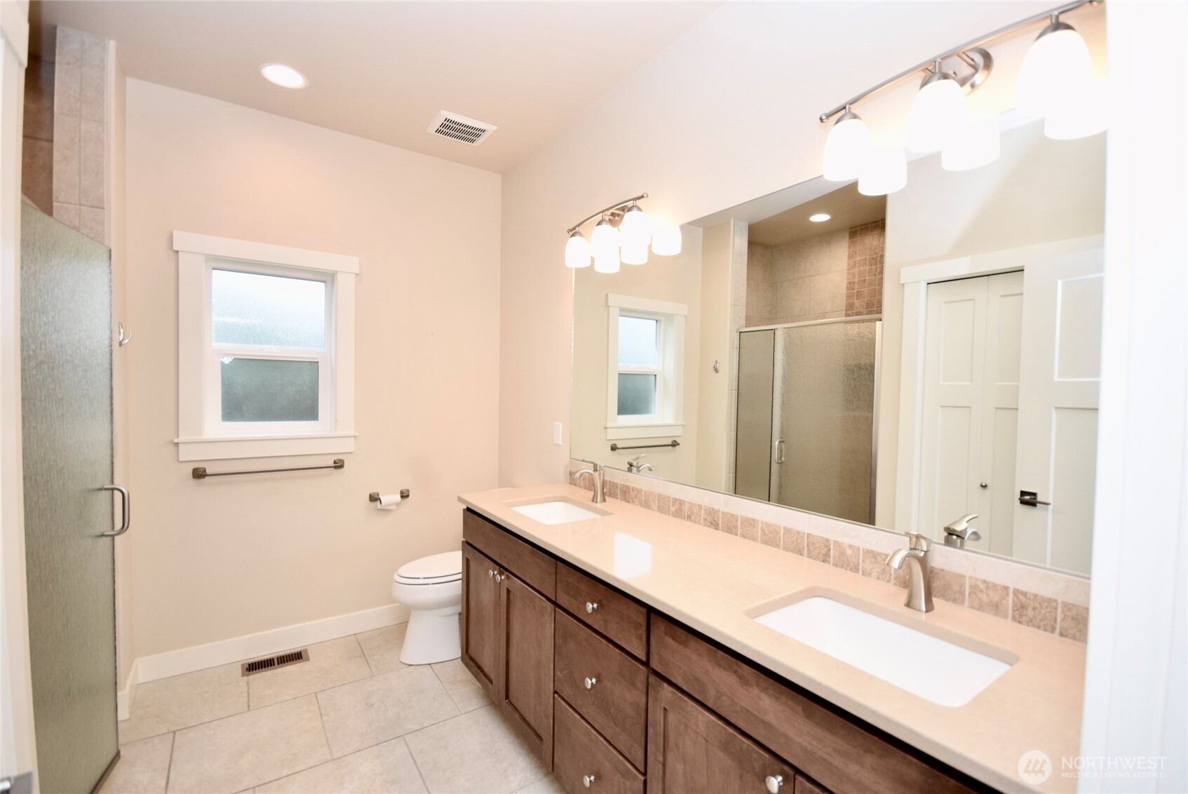 261 Mt Baker Drive, Unit B Sequim, WA 98382 - Photo 18 of 28 a bathroom with a granite countertop double vanity sink a mirror and a shower