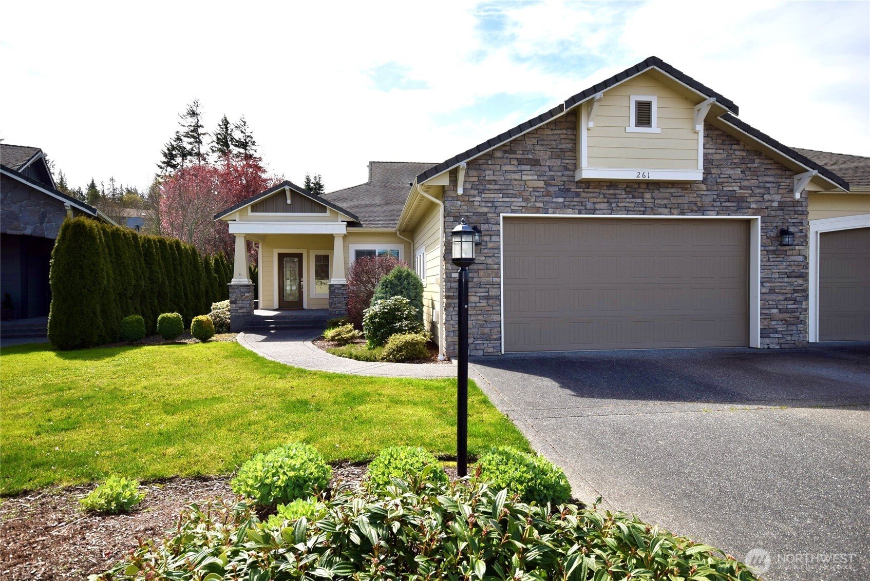 261 Mt Baker Drive, Unit B Sequim, WA 98382 - Photo 2 of 28 a front view of a house with a yard and garage