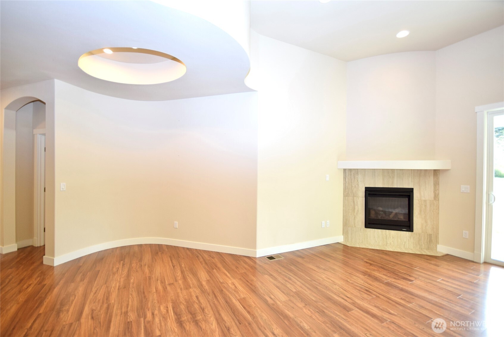 261 Mt Baker Drive, Unit B Sequim, WA 98382 - Photo 9 of 28 a view of an empty room with wooden floor and a fireplace