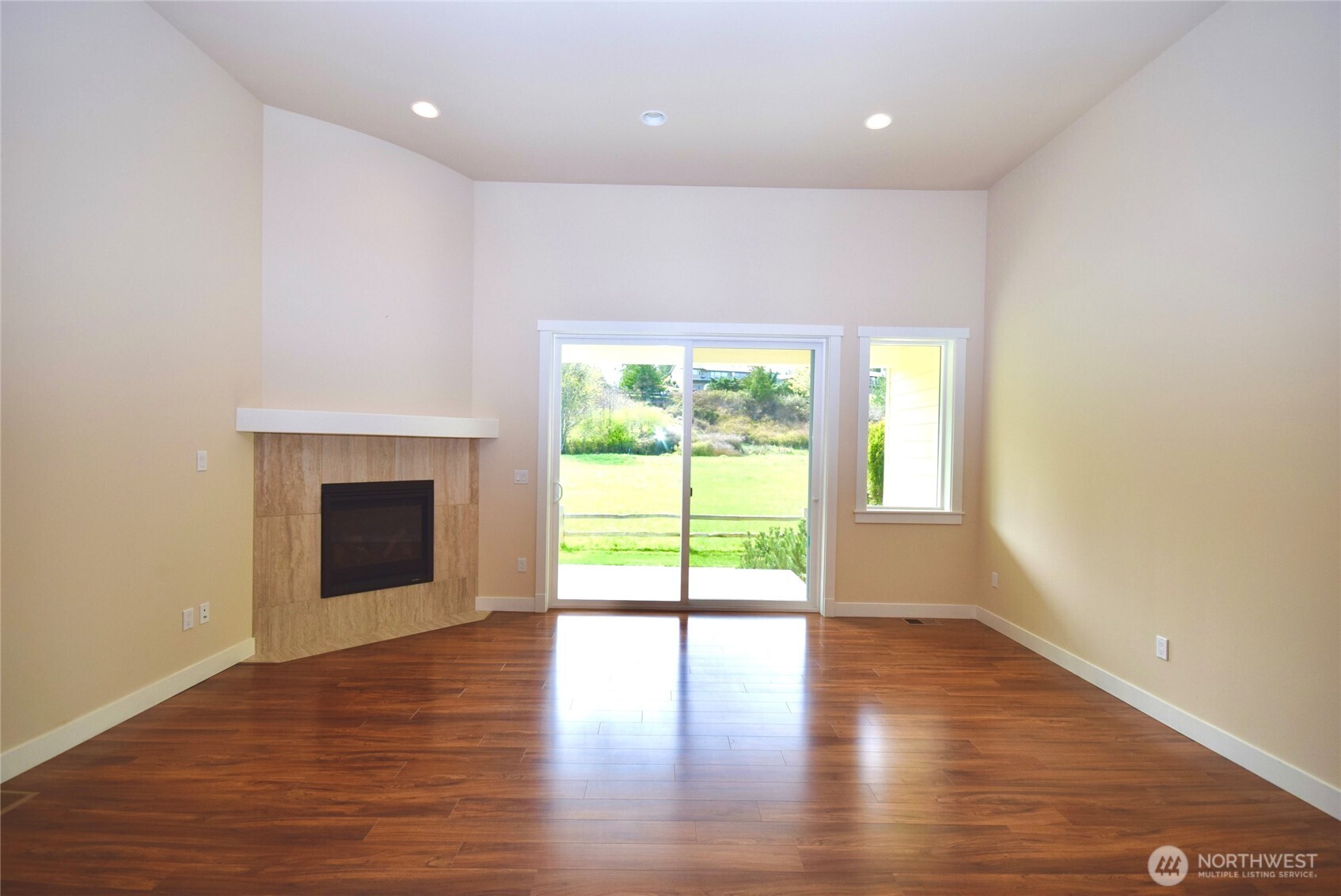 261 Mt Baker Drive, Unit B Sequim, WA 98382 - Photo 10 of 28 a view of an empty room with wooden floor and a window