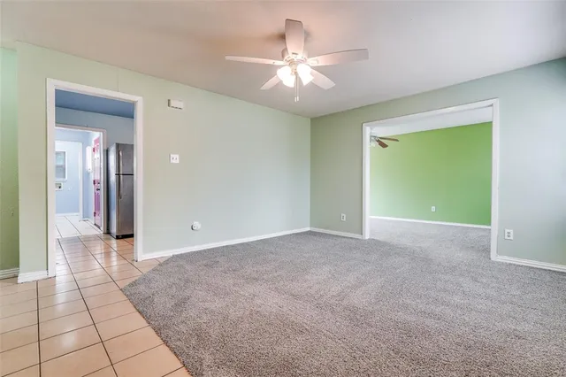 a view of a livingroom with a chandelier fan and windows