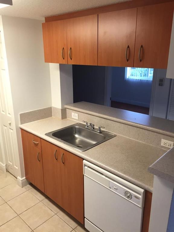 816 Northwest 11th Street, Unit 710 Miami, FL 33136 - Photo 4 of 10 a kitchen with a sink and a refrigerator