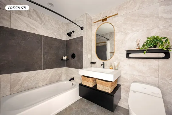 a bathroom with a sink mirror and tub