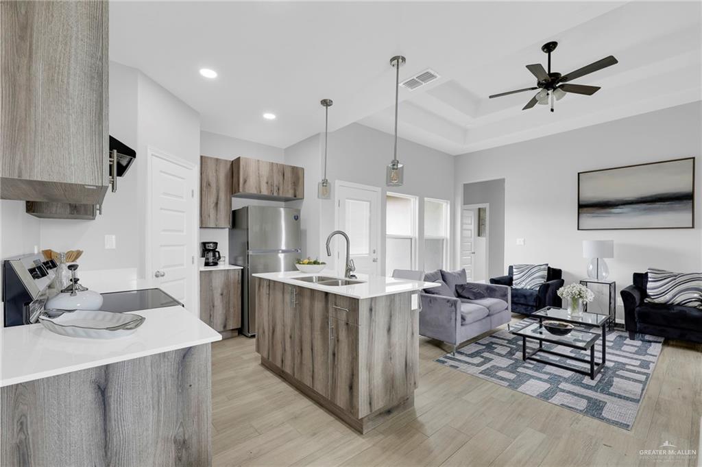 600 Bridget Street Weslaco, TX 78596 - Photo 7 of 23 a kitchen with stainless steel appliances kitchen island granite countertop a table chairs in it and white cabinets