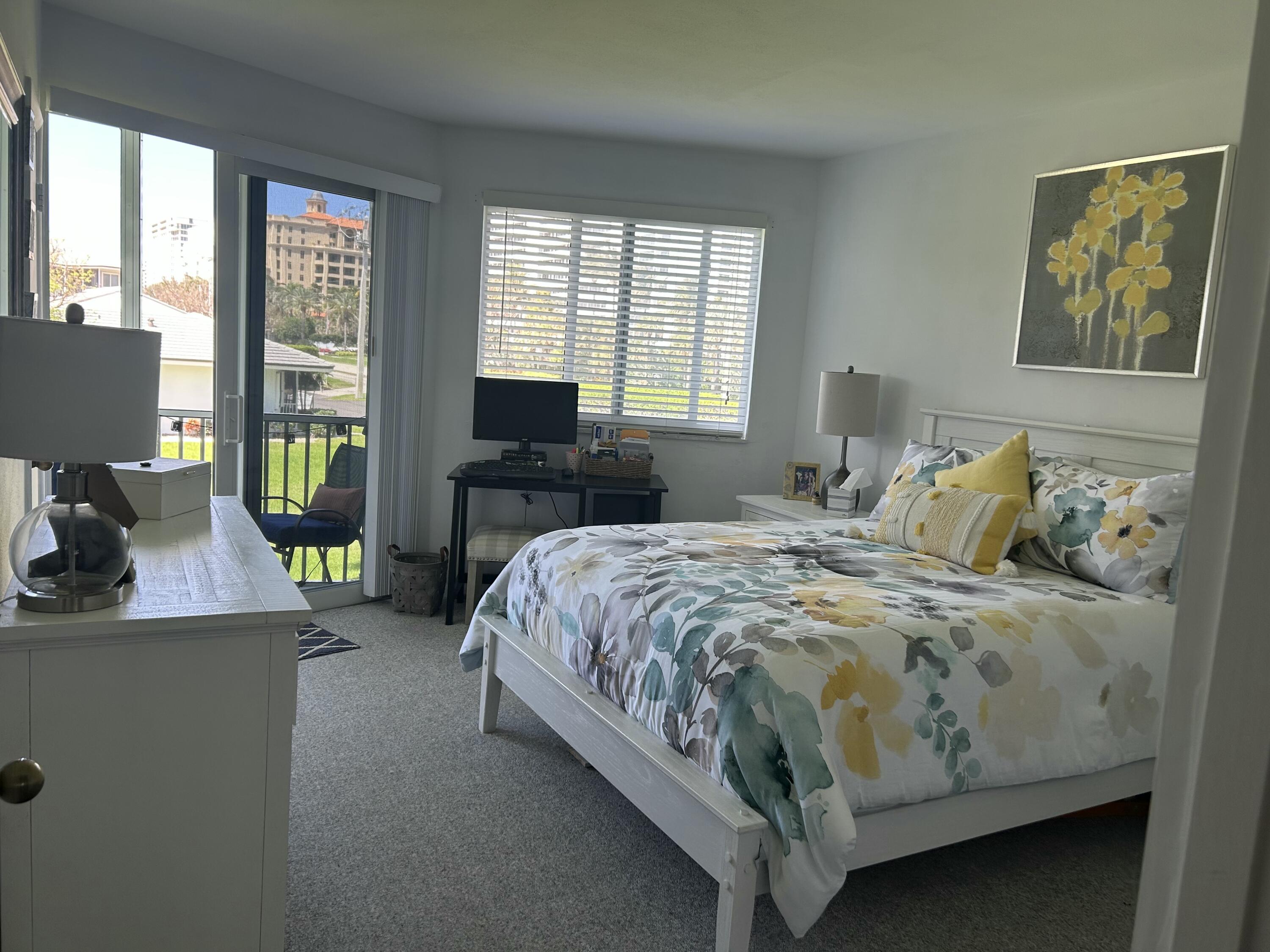 a bedroom with a bed and large windows