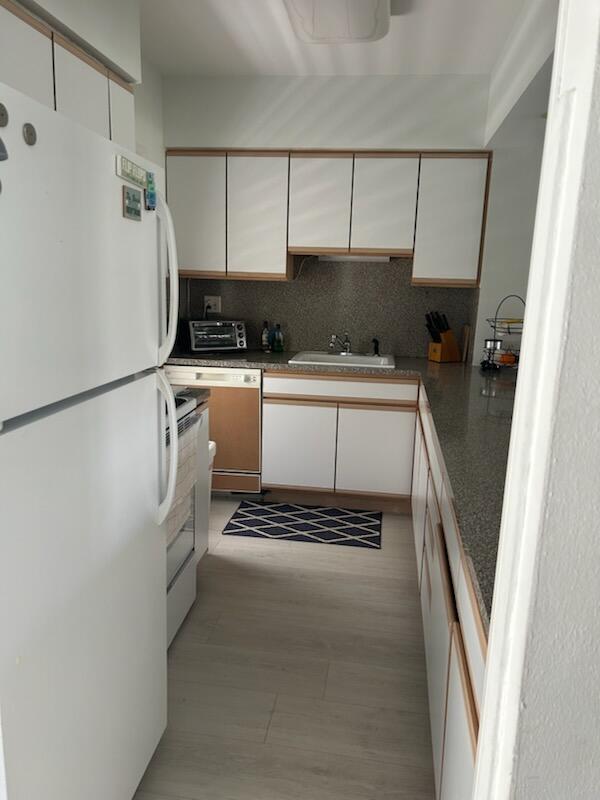 2760 Banyan Road, Unit 25A Boca Raton, FL 33432 - Photo 3 of 12 a kitchen with a refrigerator and a sink