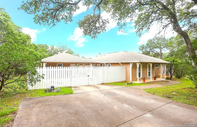 a front view of a house with a yard and trees