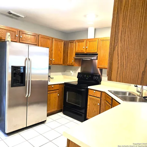 a kitchen with granite countertop a refrigerator and a sink