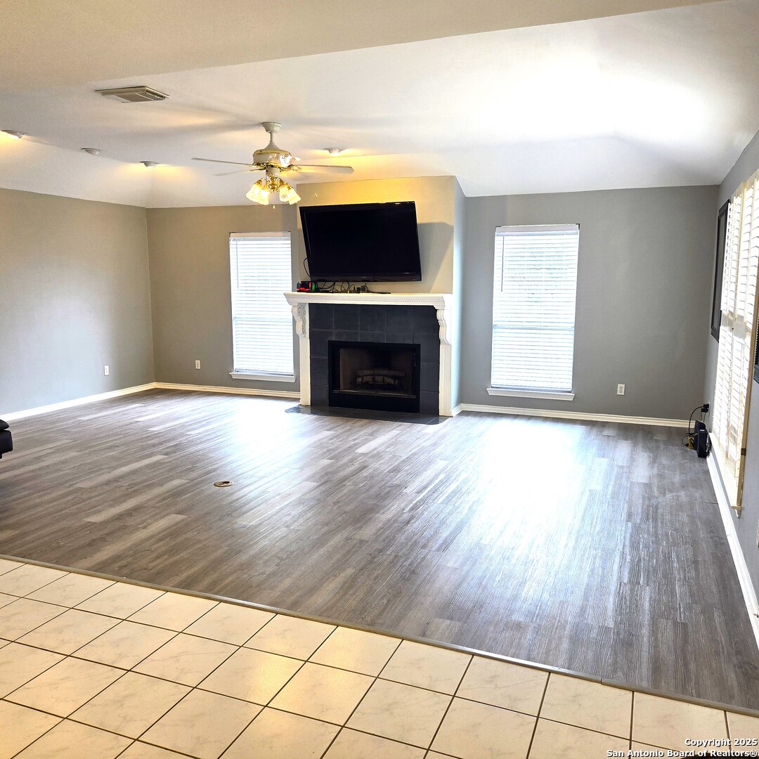23007 South Breeze Street San Antonio, TX 78258 - Photo 8 of 27 an empty room with wooden floor fireplace and windows