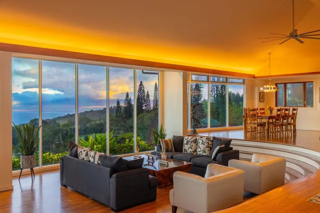 a living room with furniture and floor to ceiling windows